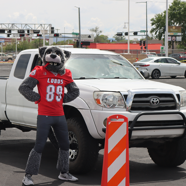 Lobo Louie standing in front of a truck.