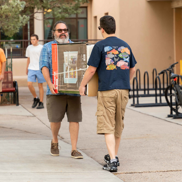 Two men moving a box