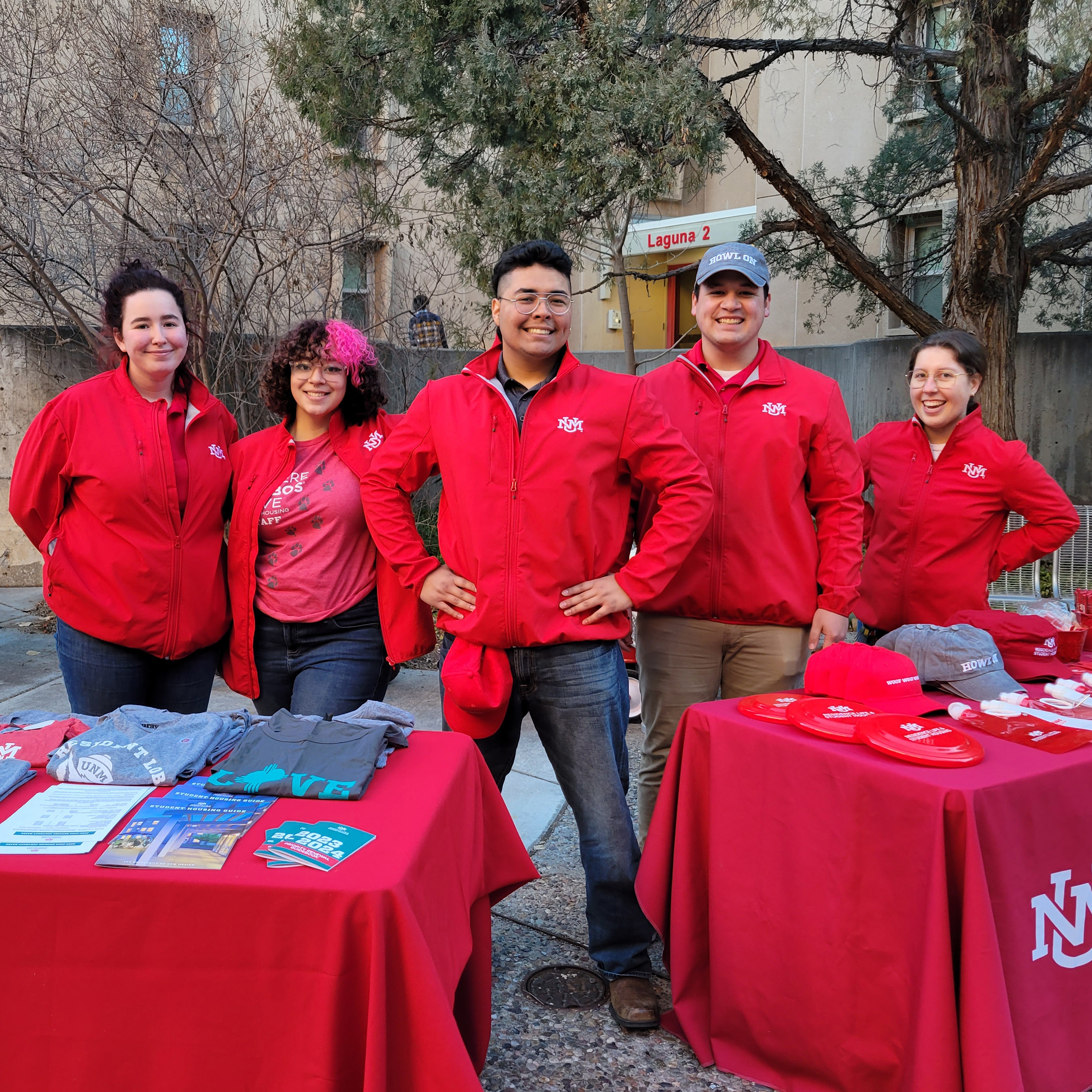 Picture of housing ambassadors standing in front of a table with promotional merch